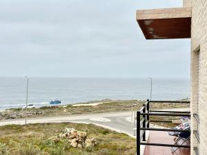 a balcony with a view of a road and the ocean at Deluxe Oceanfront - Vue Sur la Mer in Peniche
