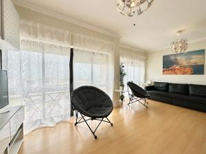 a living room with a black couch and chairs at Deluxe Oceanfront - Vue Sur la Mer in Peniche