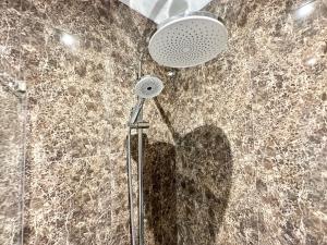 a shower with a shower head on a marble wall at Deluxe Oceanfront - Vue Sur la Mer in Peniche