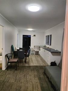 a living room with a kitchen and a dining room at Small 3 bedroom Garden Chalet B in Auckland