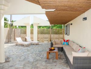 een patio met een bank, een tafel en een parasol bij Helion Apartments in Gouvia