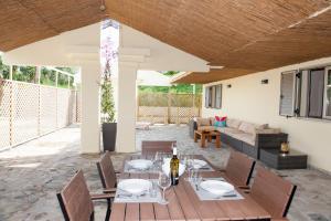 een patio met een tafel en stoelen en een bank bij Helion Apartments in Gouvia
