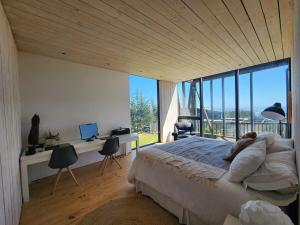 a bedroom with a large bed and a large window at Punta de Lobos Black House in Pichilemu
