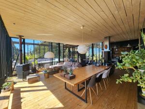 a living room with a large wooden table and chairs at Punta de Lobos Black House in Pichilemu