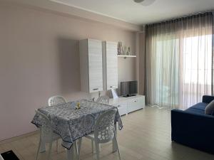 a dining room table and chairs in a living room at Appartamento Azzurro in Roseto degli Abruzzi