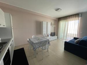 a kitchen and living room with a table and a couch at Appartamento Azzurro in Roseto degli Abruzzi