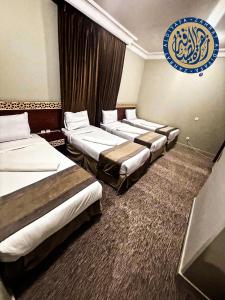 una fila de cuatro camas en una habitación de hotel en فندق تارا المحبس - محبس الجن -, en La Meca
