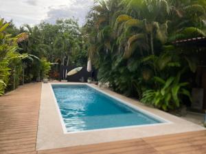 a swimming pool in a yard with palm trees at Cote Pacific Casitas in Huacas