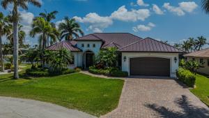a house with a driveway and palm trees at Villa Pearl in Cape Coral