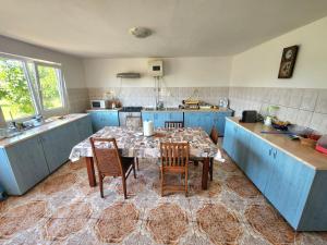 a kitchen with a table with chairs and blue cabinets at Ofidaki Glamping in Vama Veche