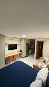 a large bedroom with a blue bed and a desk at Studio em Salvador- Vista Mar in Salvador