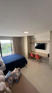 a hotel room with a bed and a desk with a tv at Studio em Salvador- Vista Mar in Salvador