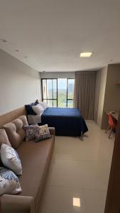 a bedroom with a couch and a bed in a room at Studio em Salvador- Vista Mar in Salvador +21 photos