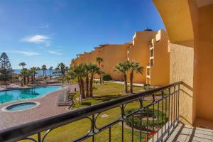 a balcony view of a resort with a pool and palm trees at Princesa De Penasco in Punta Penasco New