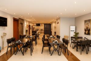 a restaurant with tables and chairs in a room at Perlina Hotel Erbil in Erbil