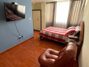 ein Wohnzimmer mit einem Stuhl und einem Bett in der Unterkunft Departamento entero dos habitaciones completamente amoblado in Arequipa