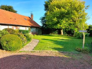 a house with a grass yard with a tree at La Mouillère in Verton