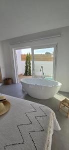 a large white bath tub in a room with a window at Casa d'Aldeia in Sonega