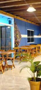 a room with wooden tables and chairs and a plant at Praieira Pousada in Itacaré