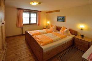 OpfenbachにあるTannenhof Eppleのベッドルーム1室(オレンジと白のシーツが入ったベッド1台付)