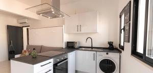 a kitchen with white cabinets and a washer at Mi Casa Es Su Casa Nº3 in Albufeira +3 photos
