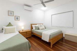 a bedroom with two beds and a large screen at The Lookout in Belgian Gardens +22 photos