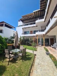 eine Terrasse mit Tisch und Stühlen und einem Sonnenschirm in der Unterkunft Tortugas uno cero tres in Puerto Escondido