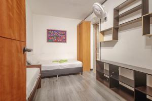 a small room with two beds and a closet at Hostal Machu Picchu Medellin in Medellín