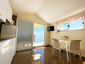 kuchnia ze stołem i krzesłami oraz oknem w obiekcie Apartments and rooms by the sea Zivogosce - Porat, Makarska - 2733 w mieście Živogošće +50 zdjęć