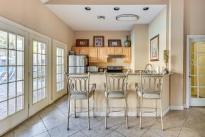 a kitchen with a counter and two bar stools at Saltwater Pool and 4 Mi to Beach Clearwater Condo! in Clearwater