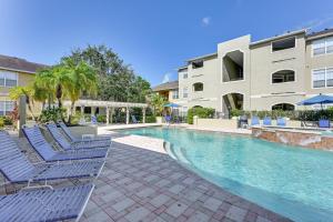 a swimming pool with chairs and a building at Saltwater Pool and 4 Mi to Beach Clearwater Condo! in Clearwater