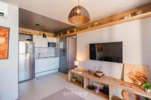 uma cozinha com uma tv na parede em Apartamento a 180m da Praia na Barra OCB0901 em Salvador