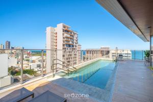 uma piscina na varanda de um prédio em Apartamento a 180m da Praia na Barra OCB0901 em Salvador