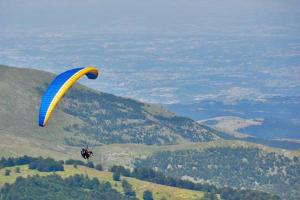 a person is flying in the air with a parachute at Vikendica Ilić in Polom