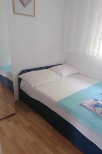 a small bedroom with a bed and a window at Apartments by the sea Bilice, Krka - 23875 in Šibenik