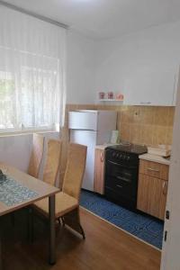 a kitchen with a table and chairs and a refrigerator at Apartments by the sea Bilice, Krka - 23875 in Šibenik