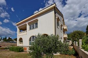 a white house with a tree in front of it at Apartments with parking space Punat, Krk - 20553 in Punat