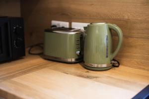 a green coffee maker and a toaster sitting on a counter at Durham Hideaway in Gilesgate