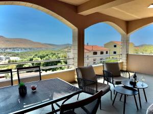 eine Terrasse mit Tischen und Stühlen auf dem Balkon in der Unterkunft Apartments Josi in Grebaštica