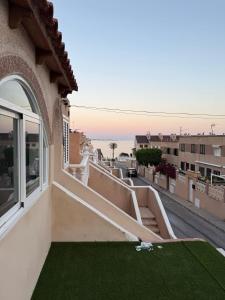 una vista dal balcone di una casa con prato verde di Villa para 12 personas en Santa Pola, frente a isla Tabarca a Gran Alacant
