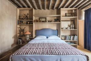 a bedroom with a large bed with a blue headboard at Odevaere - Charming & luxurious apartment with terrace in Bruges
