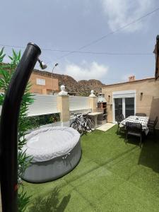 patio con tavolo e sedie sull'erba di Villa para 12 personas en Santa Pola, frente a isla Tabarca a Gran Alacant
