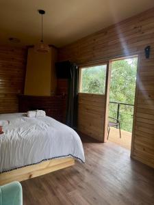 a bedroom with a bed and a sliding glass door at San José del Pacífico- Cabañas Camino al Cielo 1 in San Mateo Río Hondo