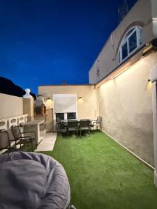 un patio con prato verde e sedie in un edificio di Villa para 12 personas en Santa Pola, frente a isla Tabarca a Gran Alacant