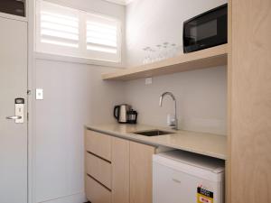 une petite cuisine avec un évier et un micro-ondes dans l'établissement Suncourt Hotel & Conference Centre, à Taupo