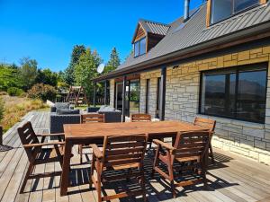 a wooden table and chairs on a wooden deck at Blue Lake Lodge - Lake Tekapo in Lake Tekapo