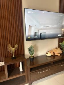 a living room with a large flat screen tv at plsa 2bedroom at airport city in Accra