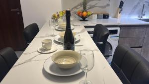 a table with a bottle of wine and glasses on it at plsa 2bedroom at airport city in Accra