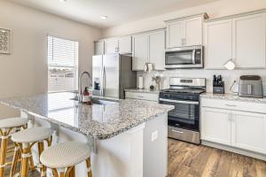 uma cozinha com armários brancos e uma grande ilha com bancos de bar em Pool Access, 2 Mi to Main St Fountain Inn Home! em Simpsonville