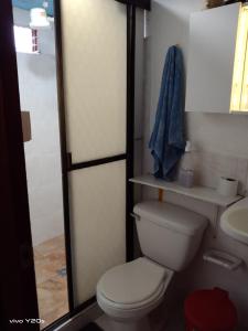 a bathroom with a toilet and a sink at Margarita, Casa Hospedaje El Cairo Valle in El Cairo